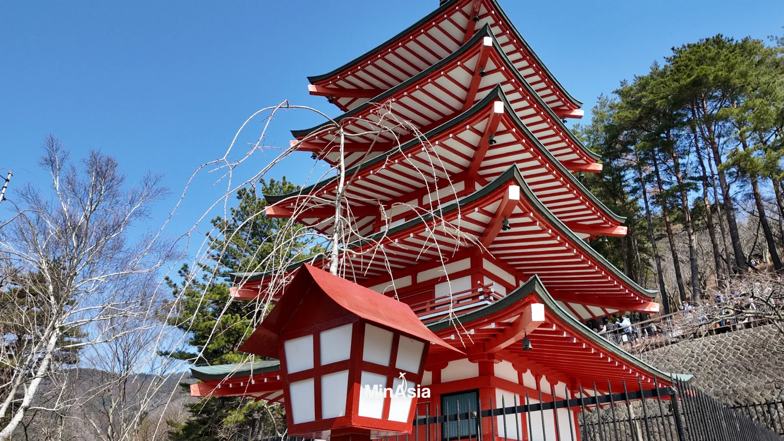 Viagem para o Japão: Jardim japonês tradicional com lanterna de pedra, lago e folhagem outonal colorida.