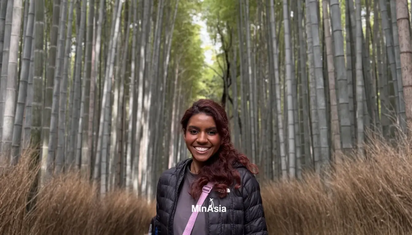 Turista caminhando e admirando os altos bambus na floresta de Arashiyama em Kyoto.