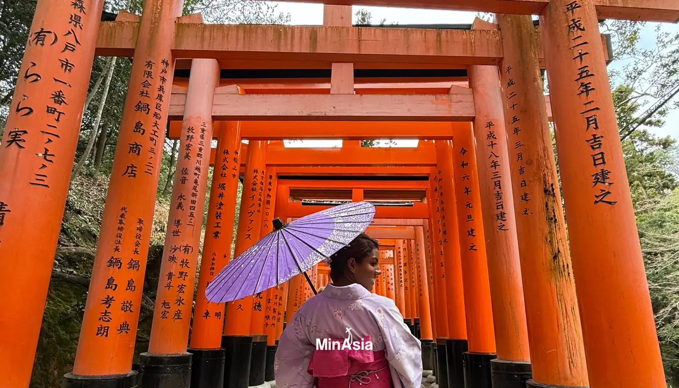 Estatua de pedra de raposa com babador vermelho no santuario Fushimi Inari em Kyoto.